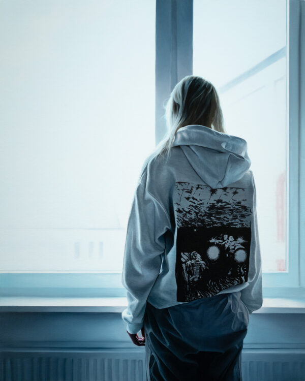 Ukranian girl por Nelson Hernández, óleo sobre panel de madera, 76 x 61 cm. Retrato de una joven de espaldas vistiendo hoodie gris claro con diseño oscuro estampado en la espalda, frente a ventana con luz fría invernal