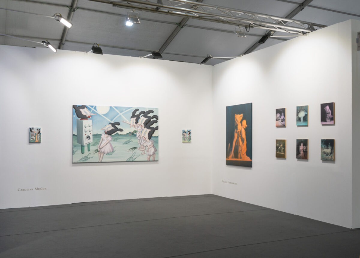 Vista amplia del stand de Isabel Croxatto Galería en CAN Art Fair Madrid 2026, con una gran pintura surrealista de Carolina Muñoz en el muro izquierdo y la serie Fever Dreams de Nelson Hernández en el derecho