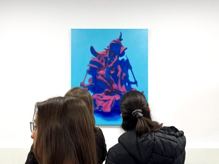 Dos visitantes observan Ozymandias II de Nelson Hernández en Loop State, D Contemporary, Londres. Pintura sobre fondo cian con forma escultórica rojiza